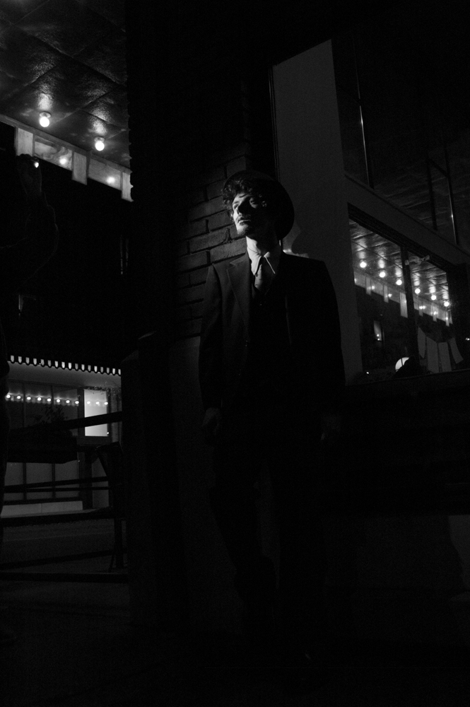 Man in suit outside of cafe at night