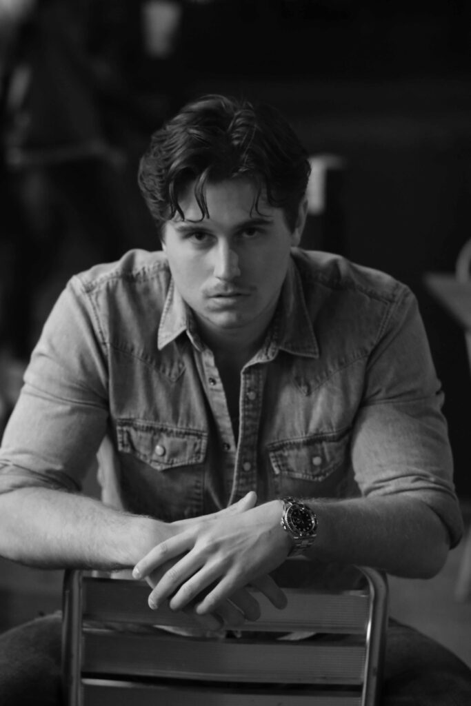 Young man sitting on chair at street cafe