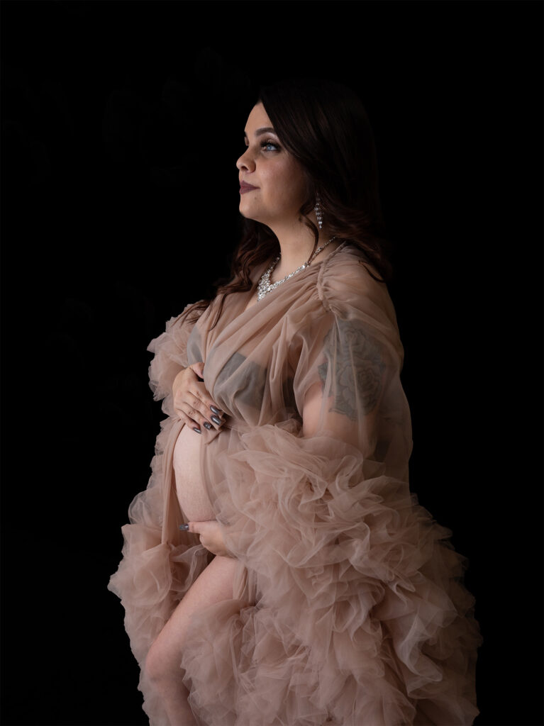 Pregnant mother holding belly and looking onward